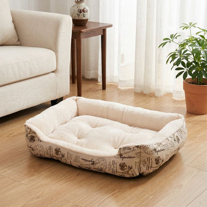 Chat panier blanc rectangulaire à rebords moelleux, posé sur un parquet près d’un canapé et d’une plante