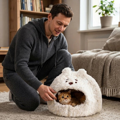 Chat qui se repose dans une niche ours polaire en peluche