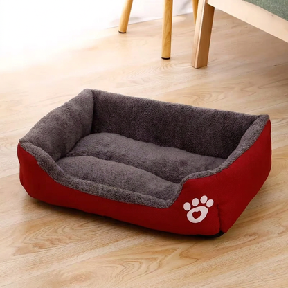 Panier pour chat XXL rouge à intérieur gris et rebords rembourrés, vu de trois quarts sur un parquet clair 